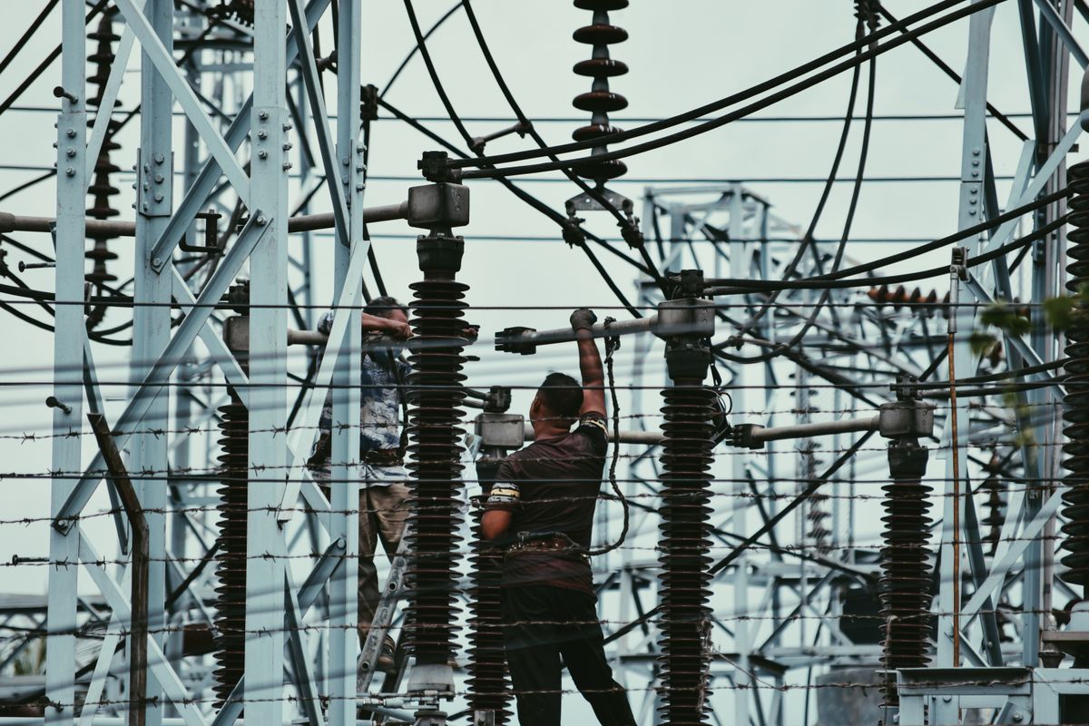 Technici pracují na vysokonapěťovém zařízení v elektrické rozvodně